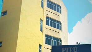 A building with a sign for "PITU gold HOTEL e RESTAURANTE SAMBURA" and a white car parked in front. - Hotel Samburá (Olinda)