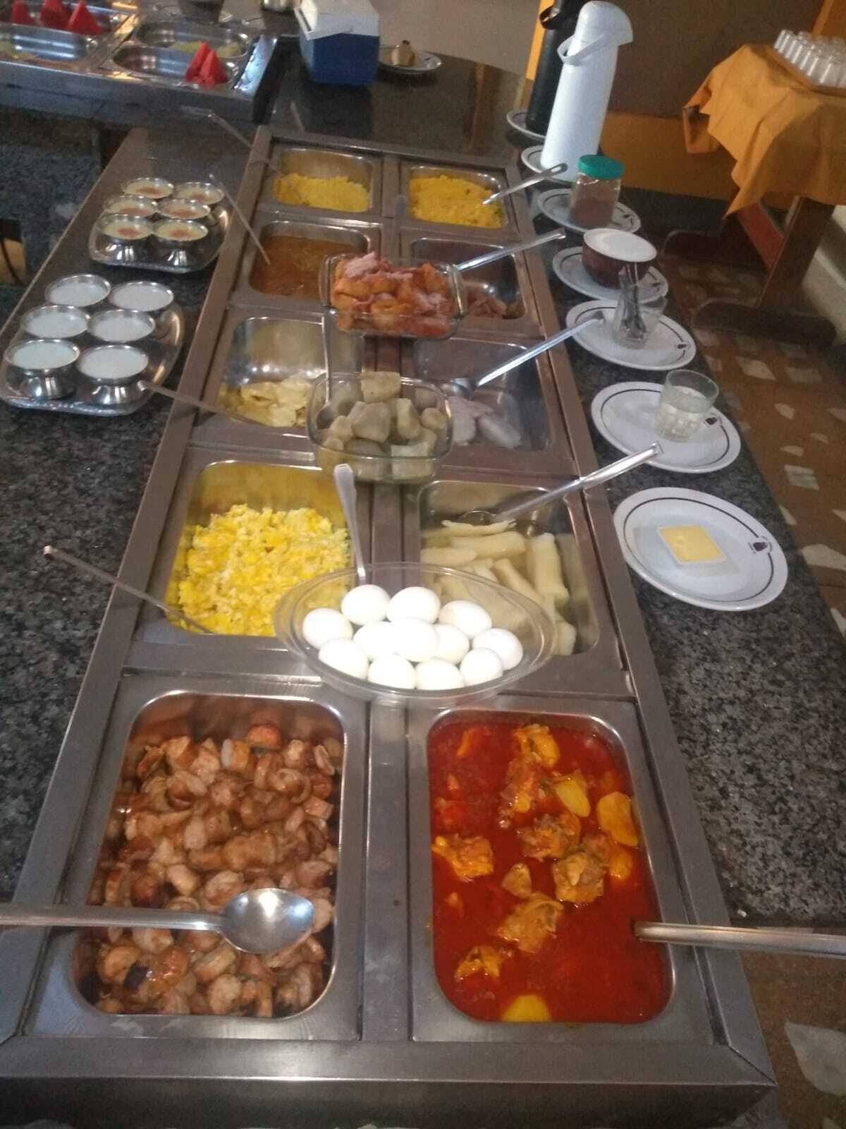 A buffet with various food items including eggs, shrimp, and a red sauce dish.