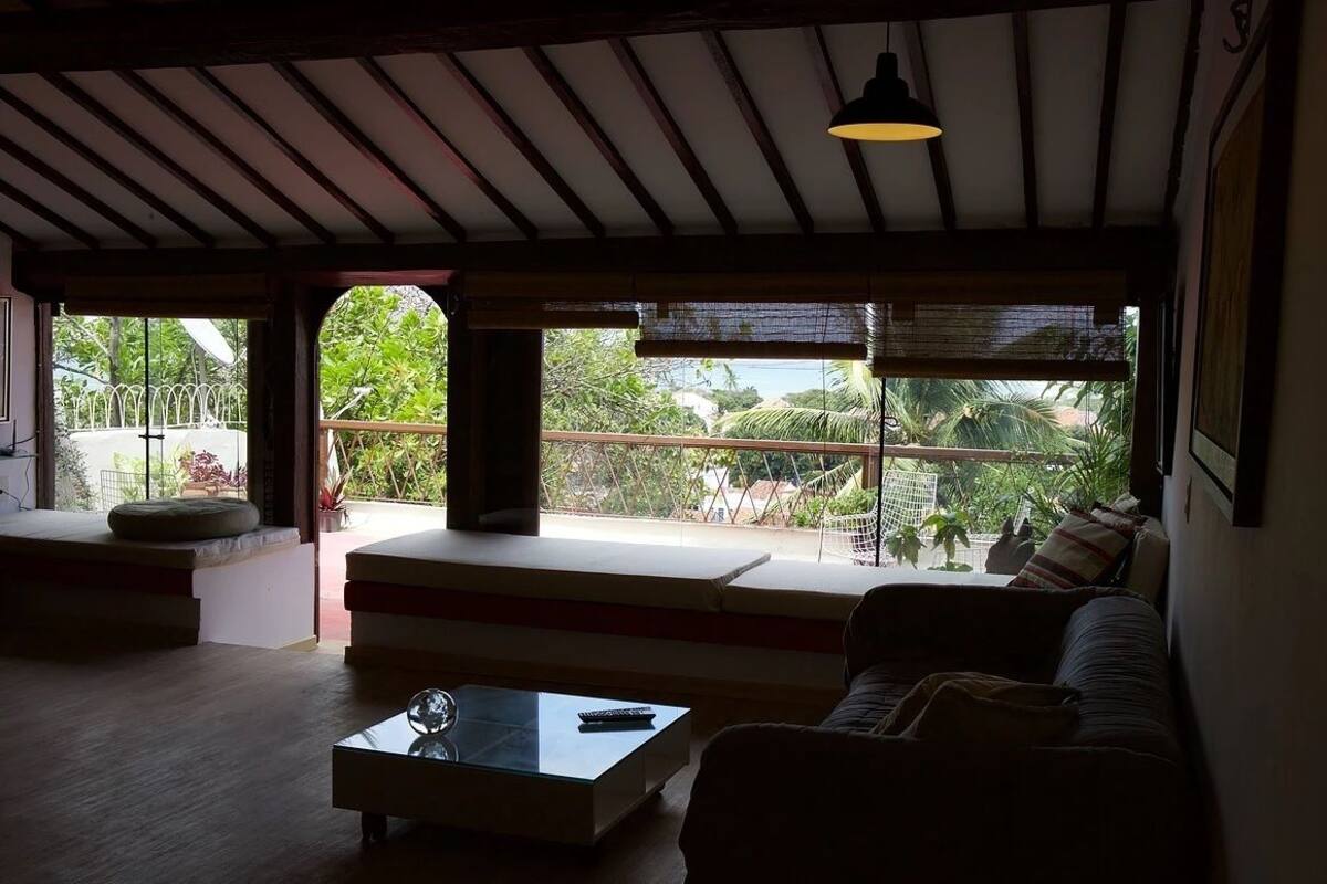 Un espai de sala d'estar ampli amb un gran finestral, un sofà, una taula de centre i un llum penjant.