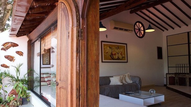 A modern living room with a sofa, a glass coffee table, and a painting on the wall. - Irradiante (Olinda)