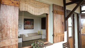 A rustic interior with exposed wooden beams, a woven ceiling, a sofa, and a framed picture on the wall. - Irradiante (Olinda)