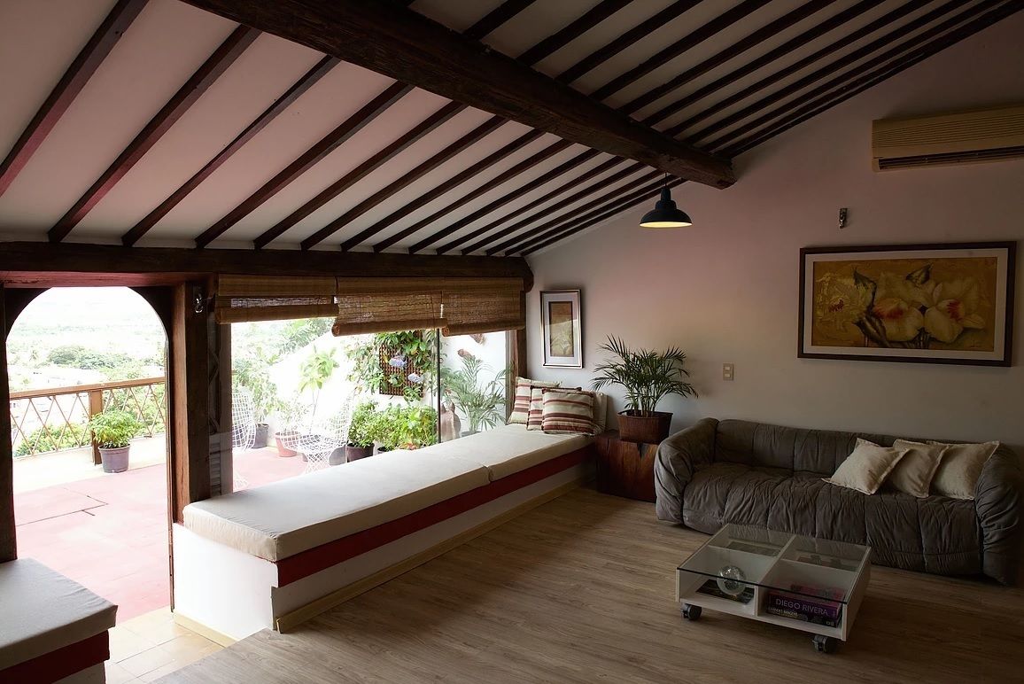 A cozy living room with a wooden ceiling, a sofa, a bench, and a coffee table.