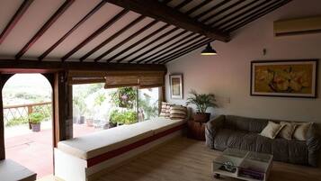 A cozy living room with a wooden ceiling, a sofa, a bench, and a coffee table.