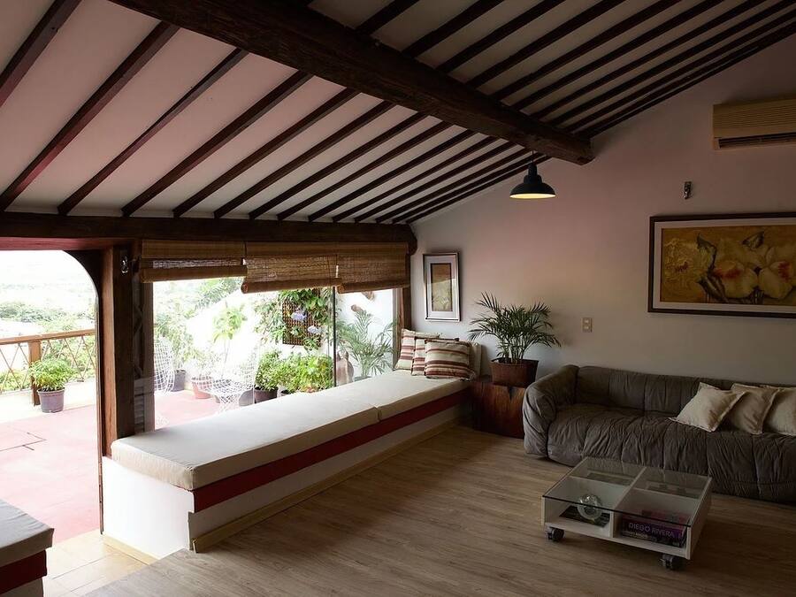 A cozy living room with a wooden ceiling, a sofa, a bench, and a coffee table.