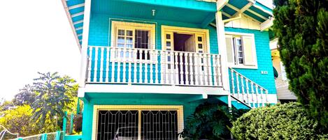 A two-story house with a blue and white exterior, a balcony, and a garage.