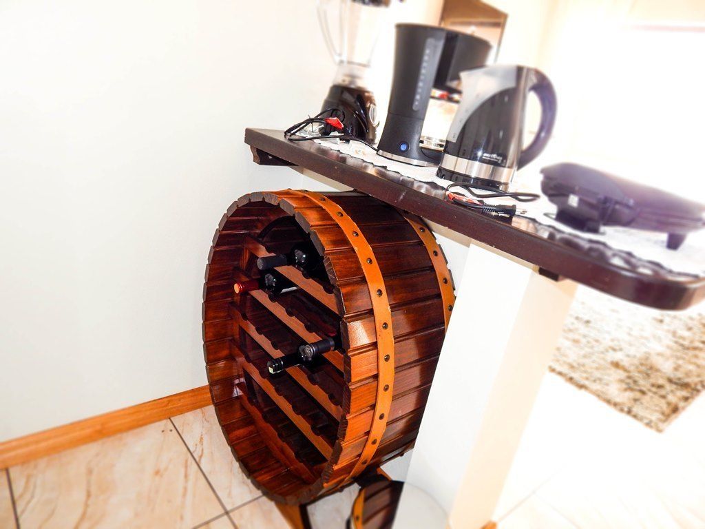 Un tonneau en bois cerclé de métal, un appareil électronique noir et un objet blanc posé sur une table.