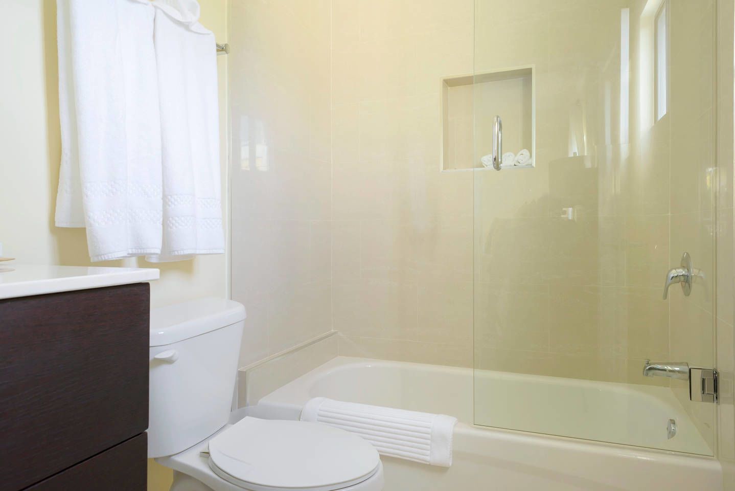 A bathroom with a toilet, a bathtub, and a glass-enclosed shower area.