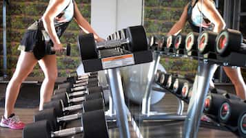 Un gimnasio con filas de mancuernas y equipamiento de ejercicio.