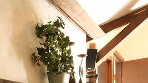 Una escalera de madera con barandilla de metal y una planta en el descansillo.