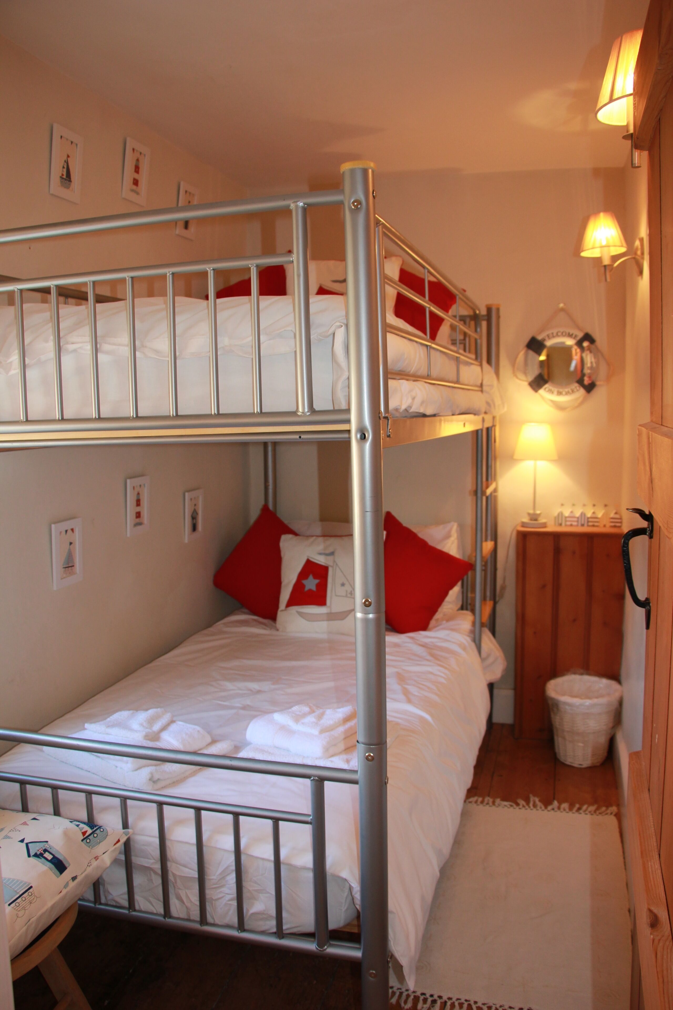 A bunk bed room with a wooden cabinet and a lamp.