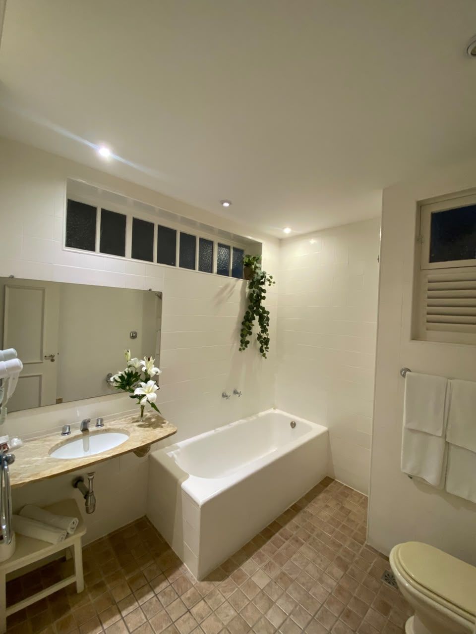 A bathroom with a bathtub, a sink, a toilet, and a mirror.
