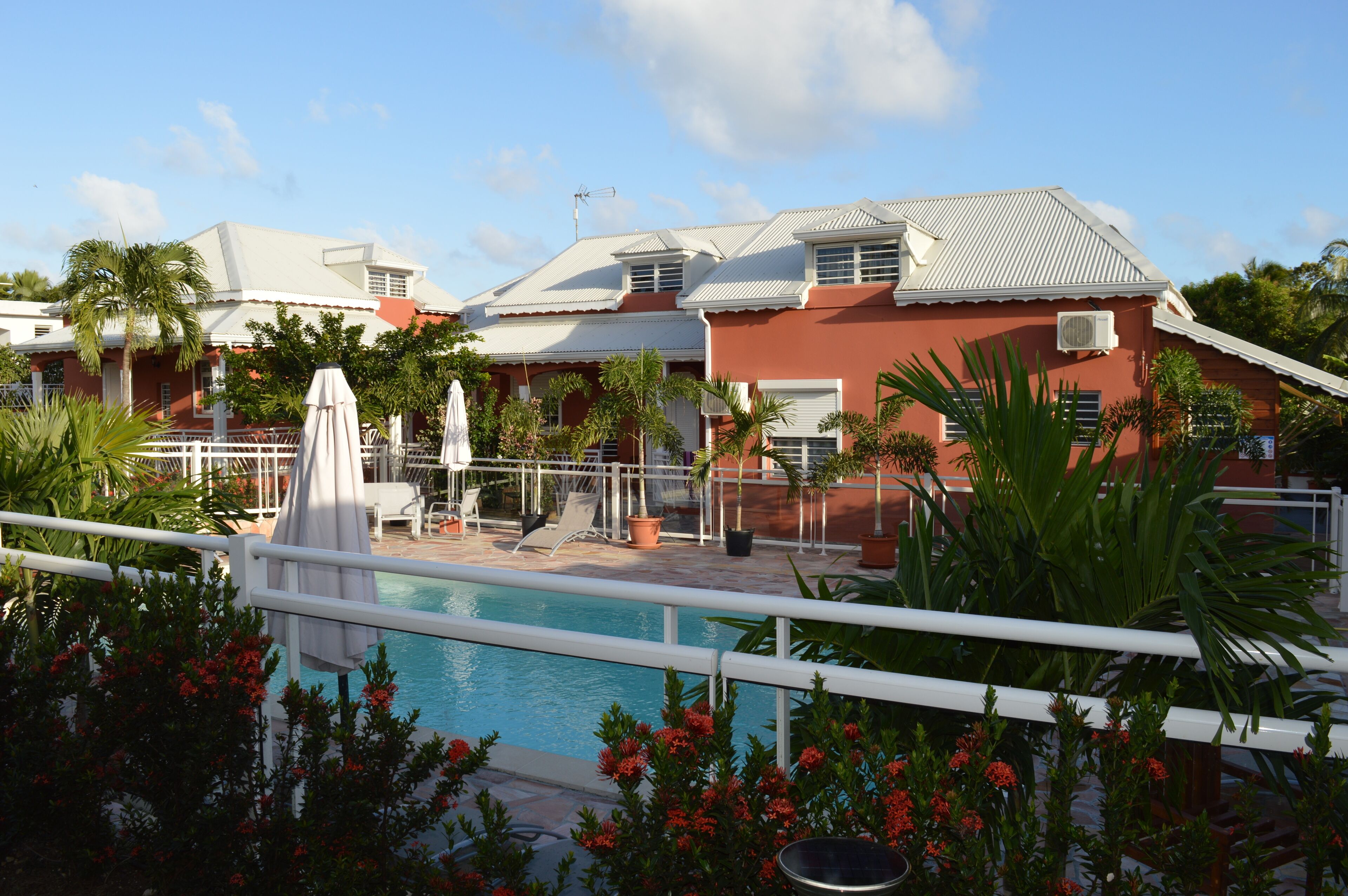 A pool area with a fountain, lounge chairs, and potted plants.