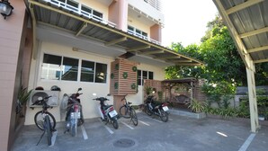 A building with a covered parking area, a bicycle, and a motorcycle. - The 1 Place Khonkaen (Khon Kaen)
