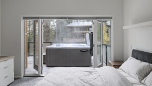 A bedroom with a large sliding glass door leading to a balcony with a hot tub. - Just completed 4 bedroom, 5 bathroom modern Town home, pool table, sleeps 10 (Golden)