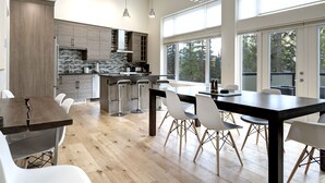 A modern kitchen with a central island, bar stools, and a dining table with chairs. - Just completed 4 bedroom, 5 bathroom modern Town home, pool table, sleeps 10 (Golden)