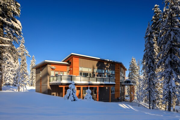 A modern two-story building with a balcony, surrounded by snow-covered trees. - Just completed 4 bedroom, 5 bathroom modern Town home, pool table, sleeps 10 (Golden)