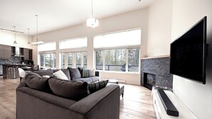A modern living room with a grey sofa, a flat-screen TV, and a fireplace. - Just completed 4 bedroom, 5 bathroom modern Town home, pool table, sleeps 10 (Golden)