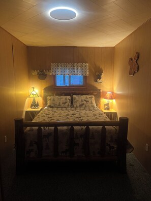 Una habitación con una cama, dos lámparas de noche, una ventana con vistas y una lámpara de techo.