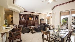 A spacious living area with a dining table, comfortable seating, and a view of the outdoors. - Luxury Los Sueños Condo - Marina, Pools & Golf. Fishermans Paradise! (Los Suenos)