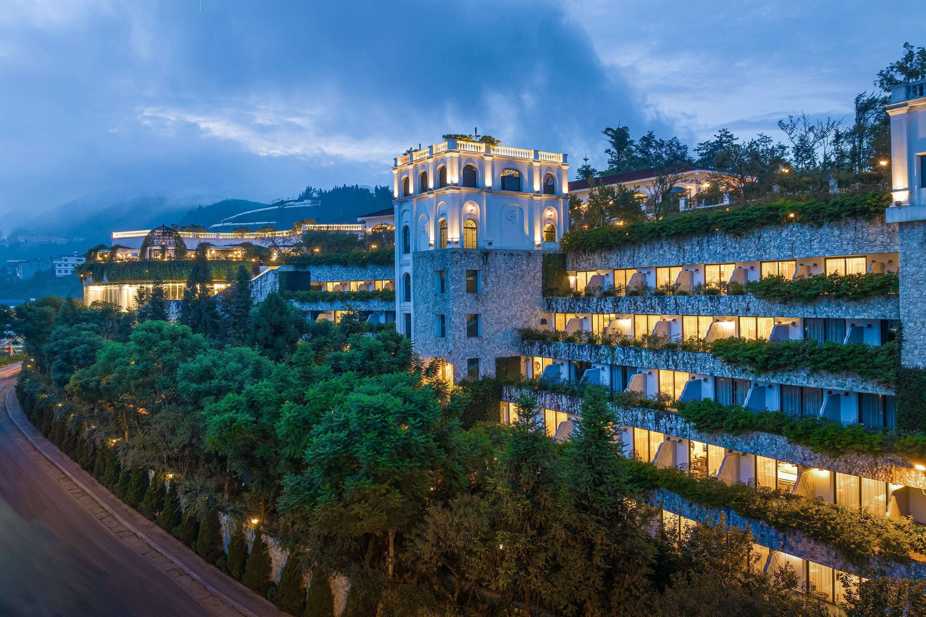 Un hotel de varios pisos con una torre destacada y balcones.