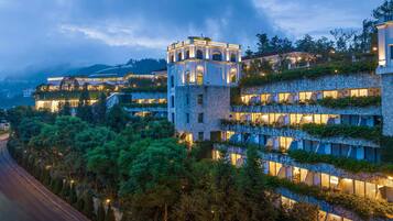 Un hotel de varios pisos con una torre destacada y balcones.