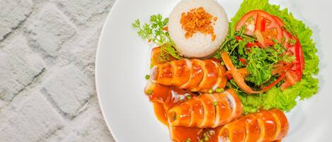 A plate of food with rice, vegetables, and a sauce.