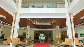 A spacious lobby with a red carpet, multiple seating areas, and a staircase leading to an upper level. - Muong Thanh Grand Tuyen Quang Hotel (Minh Xuan)