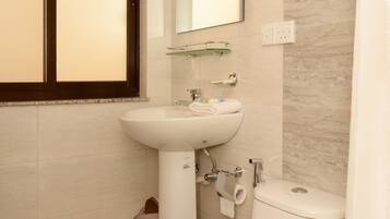 Une salle de bain avec des toilettes, un lavabo et un miroir.