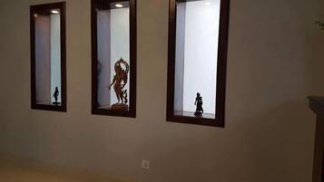 Tres espejos fijos a la pared, con una estatua en cada uno.