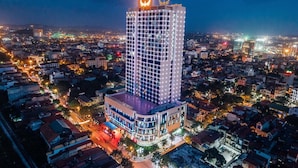 A high-rise hotel with a modern design, featuring a prominent illuminated top and a well-lit facade. - Muong Thanh Luxury Bac Ninh Hotel (Kinh Bac)