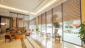 A spacious lobby with a modern design, featuring a seating area with sofas and armchairs, a coffee table, and a decorative partition. - Muong Thanh Luxury Bac Ninh Hotel (Kinh Bac)