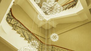 A grand staircase with ornate metal railings and multiple spherical hanging lights. - Muong Thanh Luxury Bac Ninh Hotel (Kinh Bac)