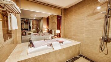 Une salle de bain moderne avec une grande baignoire, une douche et un meuble-lavabo avec un miroir.