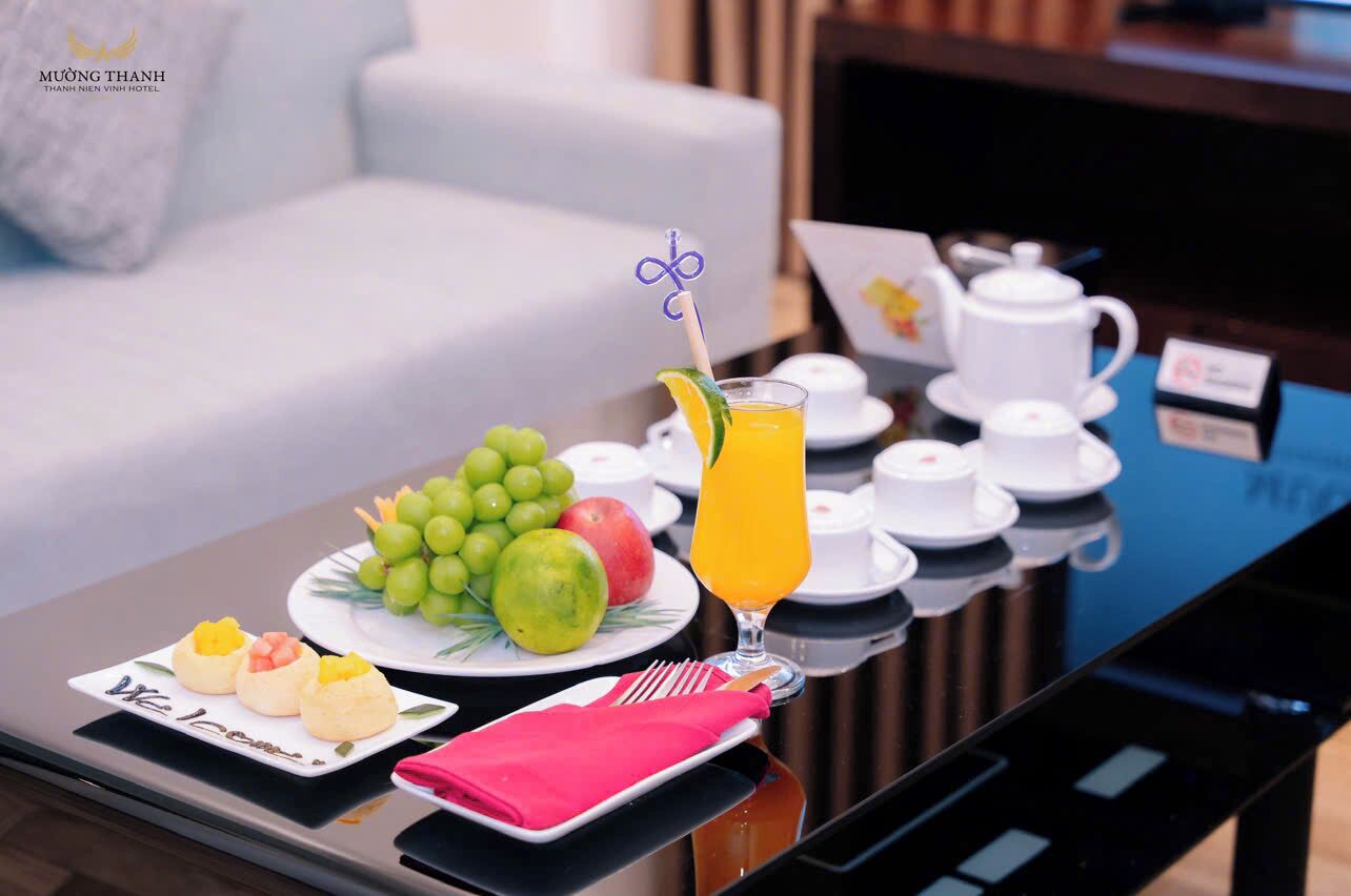 A breakfast table with fruit, juice, and tea sets.