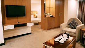 A hotel room with a TV, a bed, a sofa, a coffee table, and a wardrobe. - Muong Thanh Cua Dong Hotel (Truong Vinh)