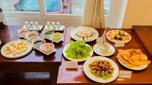 Ein Buffet mit verschiedenen Gerichten, darunter Salat, Wurst und frittierte Speisen.