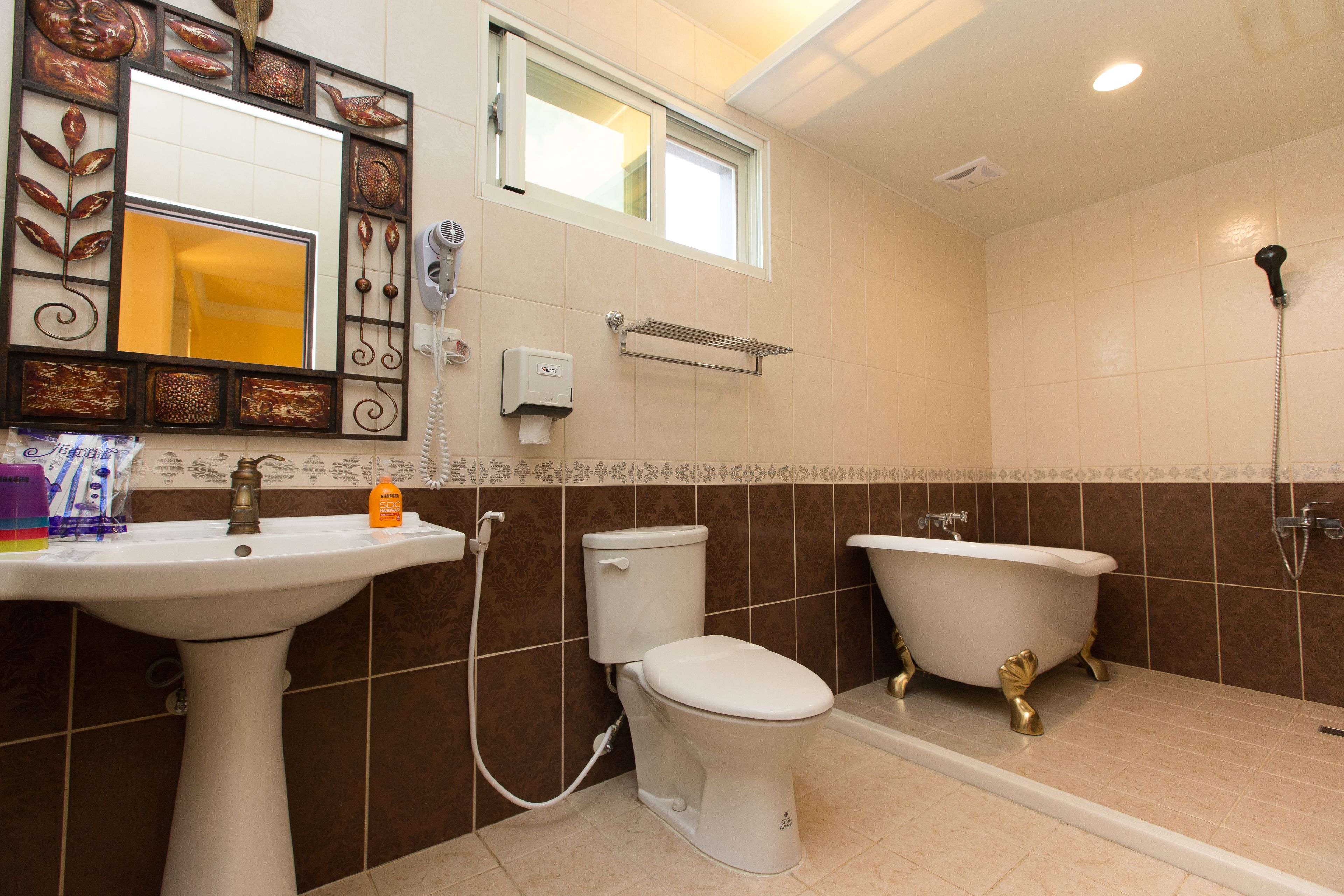 A bathroom with a pedestal sink, toilet, and clawfoot bathtub.