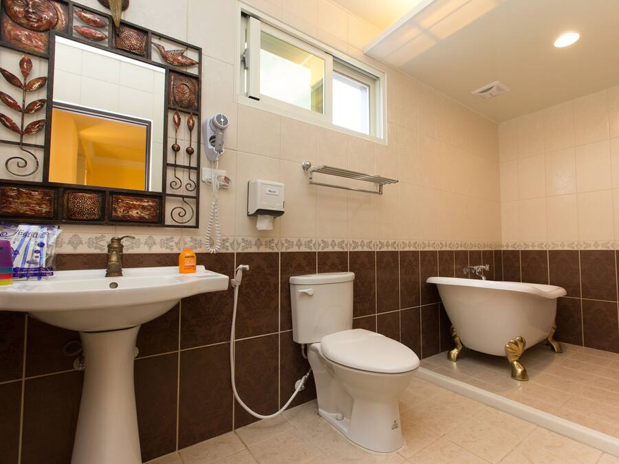 A bathroom with a pedestal sink, toilet, and clawfoot bathtub.
