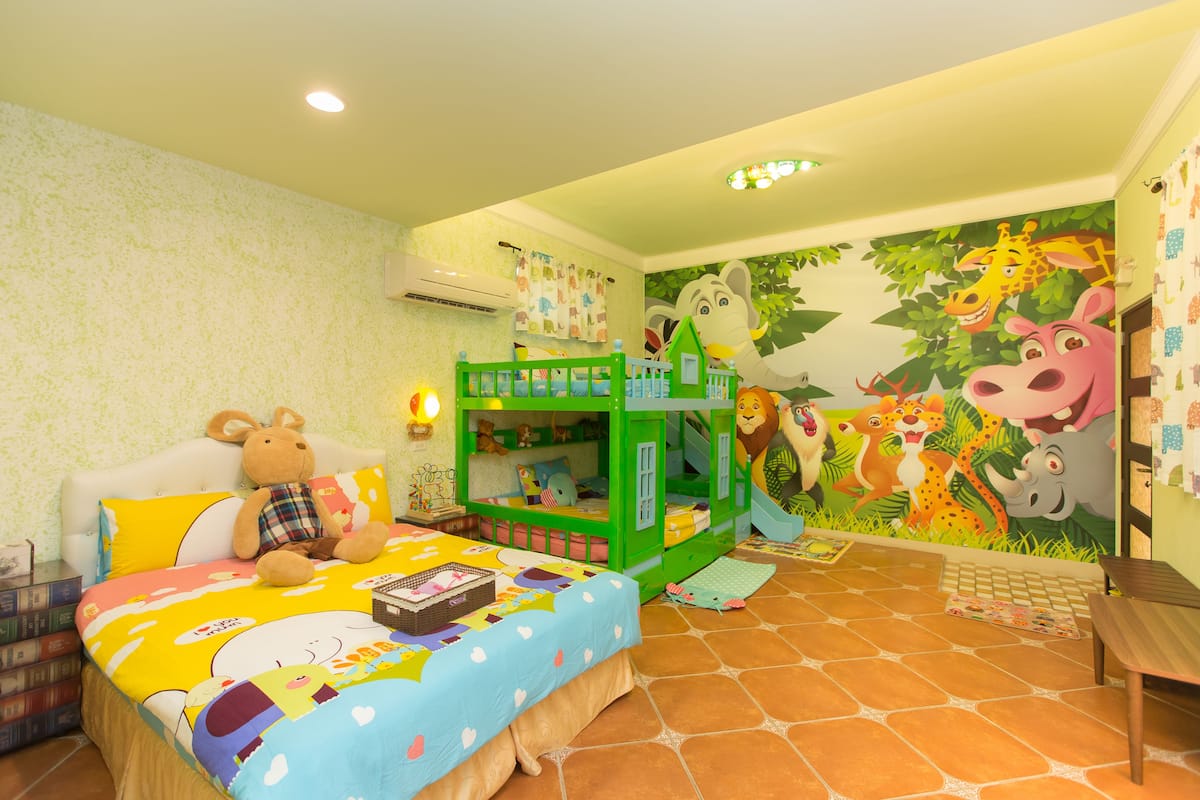 A child's bedroom with a bunk bed, a playhouse, and a mural of jungle animals.
