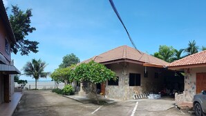 Zona residencial con casas, un camino pavimentado y vista al mar.
