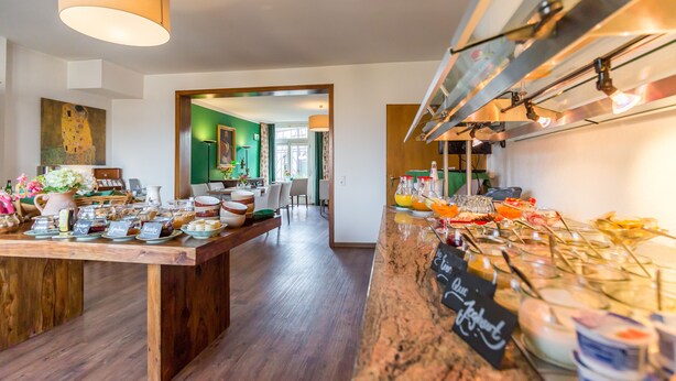 A buffet area with a variety of food items and a wooden table. - Hotel Vorderburg (Schlitz)