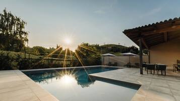 A swimming pool with a clear view of the sky and surrounding greenery.