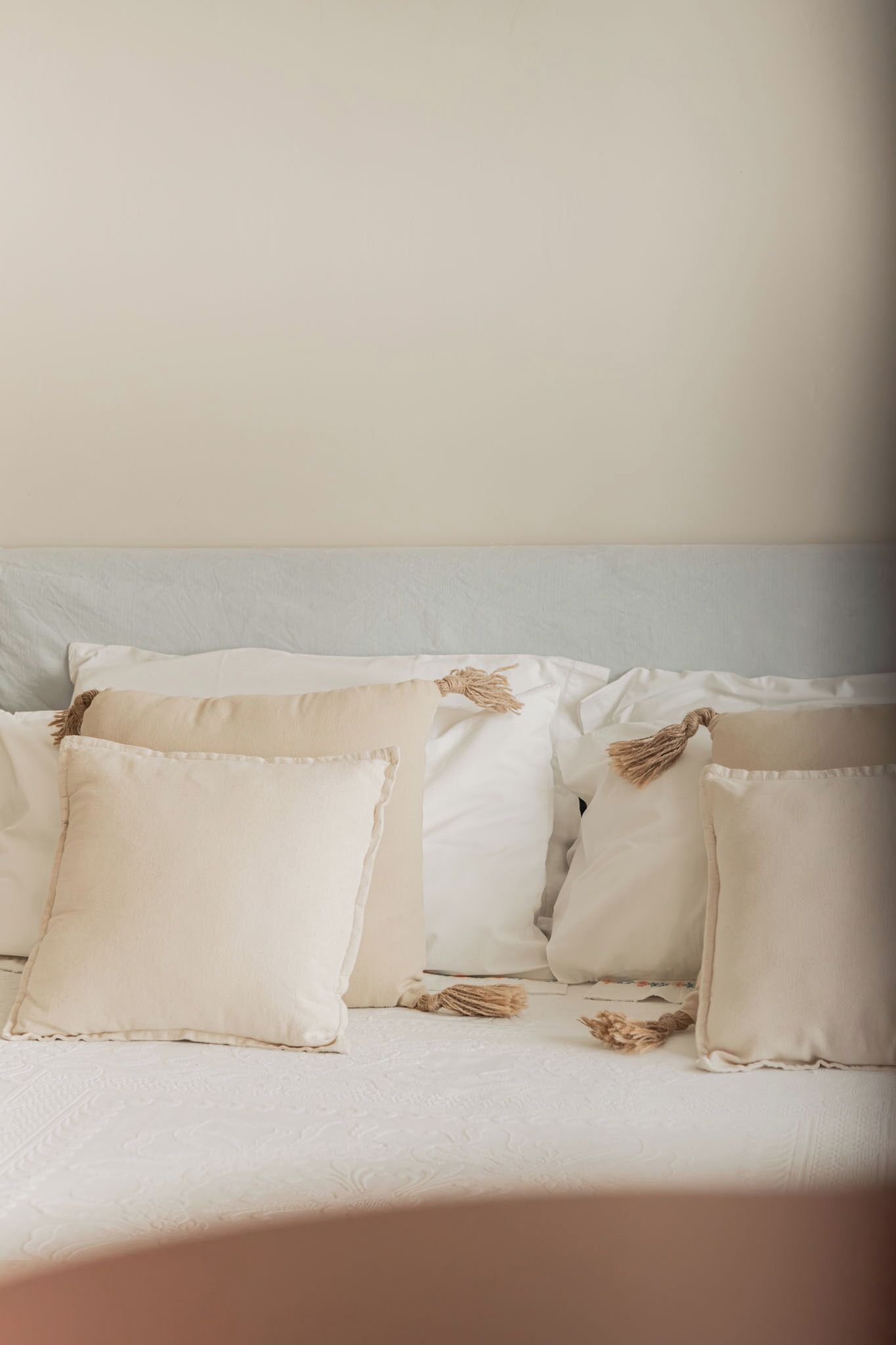 A bed with multiple pillows and a headboard.