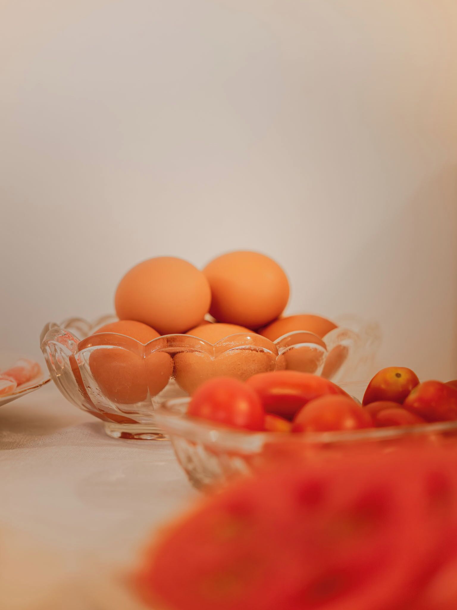 A clear glass bowl containing several eggs on a table.
