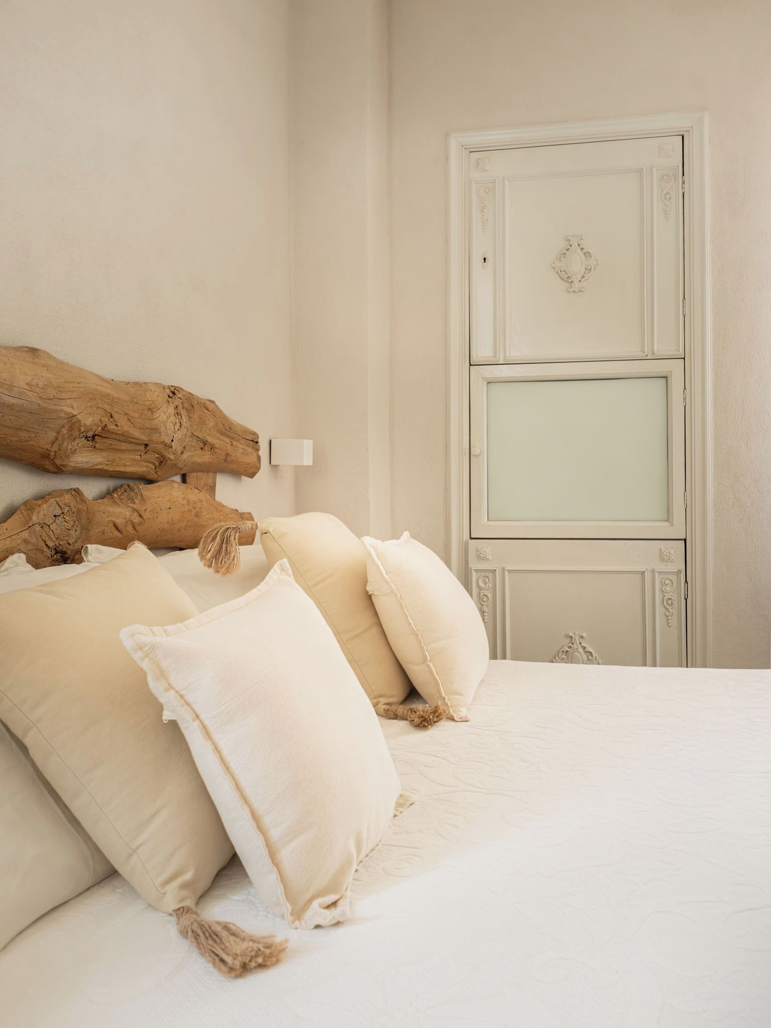 Un dormitorio con una cama grande, un cabecero de madera y una puerta blanca.