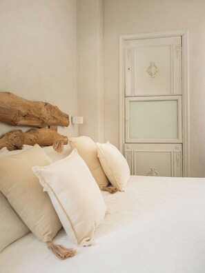 A bedroom with a large bed, a wooden headboard, and a white door. - Villa Curte Nicia (Nizza Monferrato)