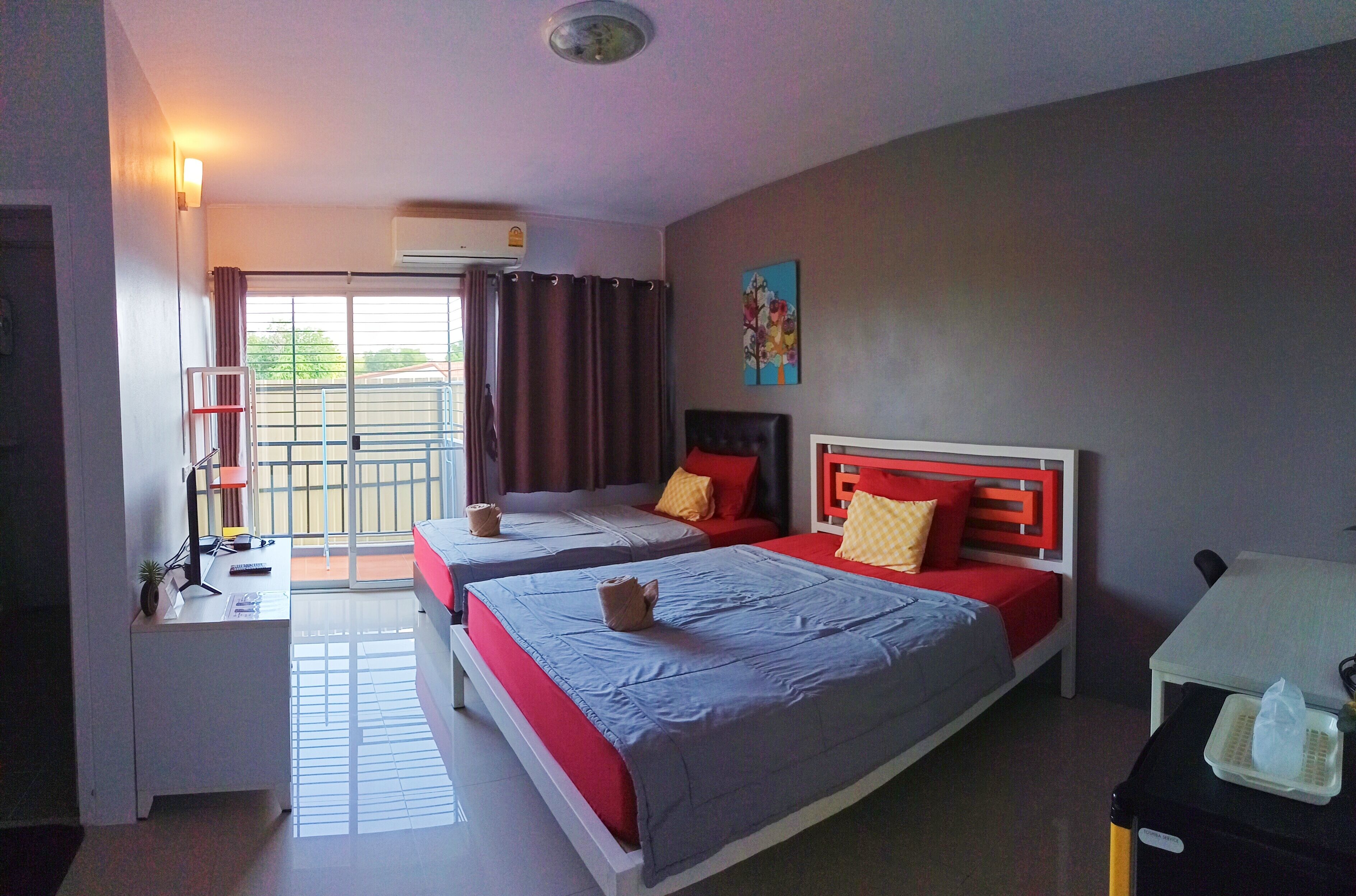 A hotel room with two beds, a desk, a chair, a table, and a window with curtains.