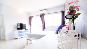 A modern, well-lit room with a bed, a TV, and a decorative white partition. - Room 9 Residence - Adult Only (Pluak Daeng)