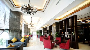 A spacious lobby with modern furniture, a large chandelier, and a bookshelf. - Chengdu Airport Jianguo Hotel (Chengdu)
