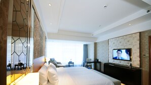 A hotel room with a large bed, a television, a desk, and a seating area. - Chengdu Airport Jianguo Hotel (Chengdu)